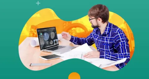 Hombre frente a la computadora dibujando estructuras