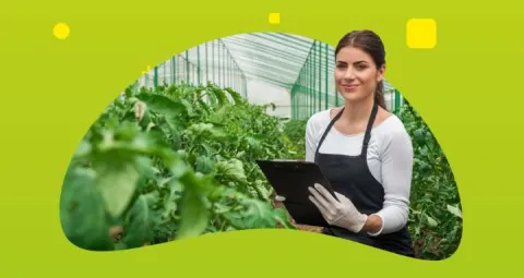 Mujer con una planilla rodeada de un cultivo
