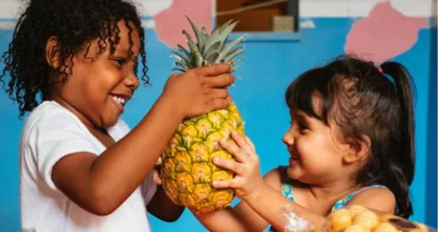 Dos niños compartiendo una piña