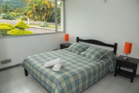 Habitación de color blanco con una cama de tendido color verde