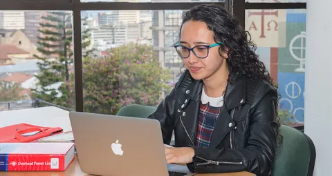 Estudiante en computador estudiando 