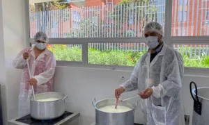 Dos participantes del curso con olla de leche