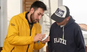  joven lasallista enseña a un habitante del sector cómo utilizar un dispositivo eléctrico.