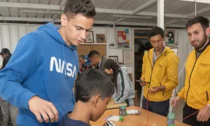 Estudiantes acompañan a niños en la construcción de pequeños circuitos eléctricos.