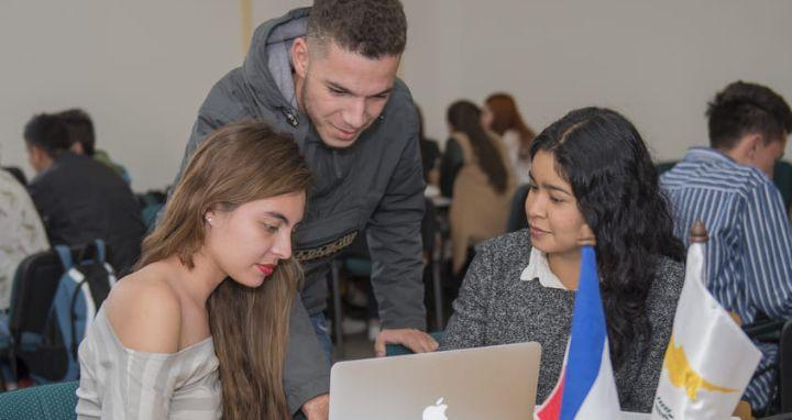 Grupo de estudiantes revisando información en el computador