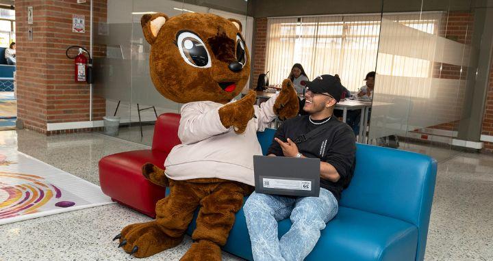 juana la mascota junto a estudiante en la biblioteca