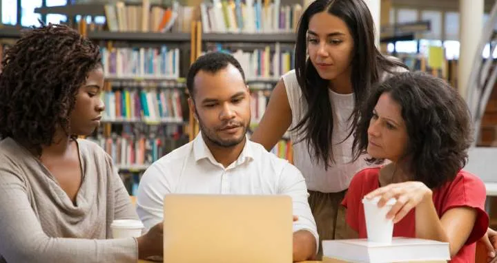 Jóvenes reunidos revisando información en un portatil