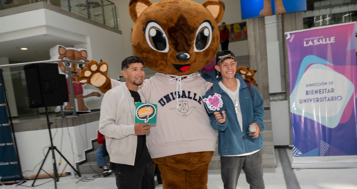 2 jóvenes junto a la mascota de unisalle Juana