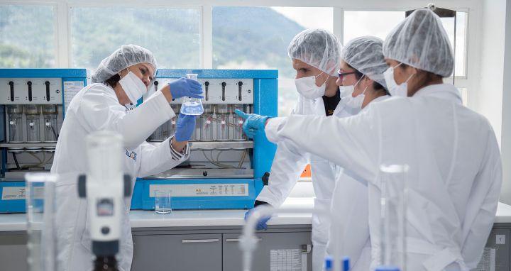 Grupo de personas en laboratorio con batas blancas