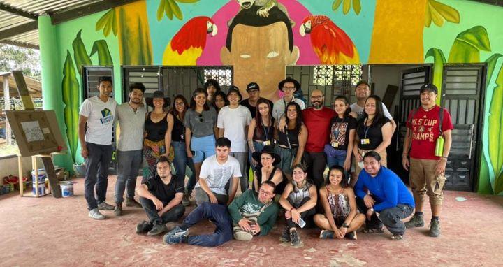 Personas organizadas en varias filas, algunas de pie y otras sentadas o...