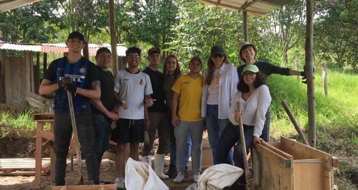 Grupo de personas trabajando bajo una estructura metálica al aire libre