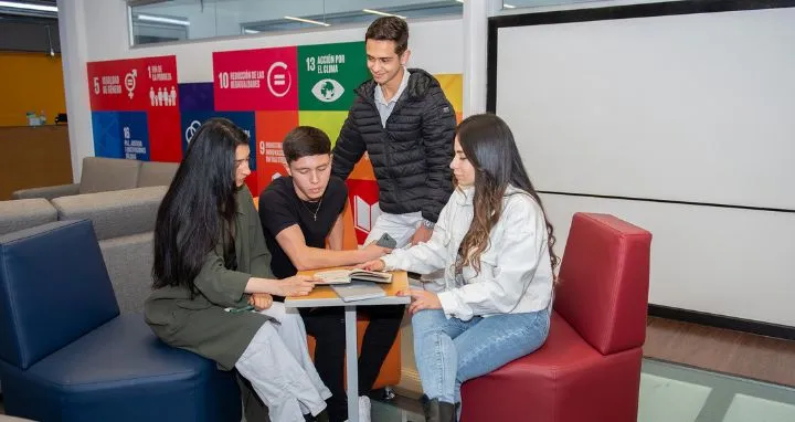 Jóvenes reunidos revisando información en un portatil
