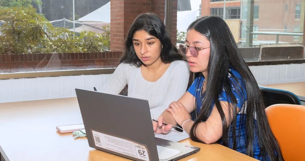 Estudiantes revisando un computador